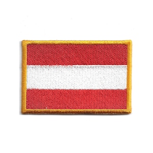 Könnte beinhalten: Gestickter Aufnäher mit der österreichischen Flagge. Der rechteckige Aufnäher hat drei horizontale Streifen: rot, weiß und rot. Ein goldener Rand umrahmt das Flaggenmotiv. Der Aufnäher ist für Kleidung oder Accessoires bestimmt.