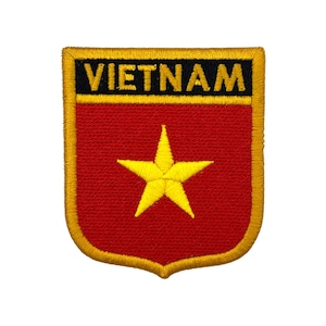 May include: Embroidered patch with the word "VIETNAM" above a red shield and a yellow star. The patch has a gold border. Suitable for application on clothing or accessories.