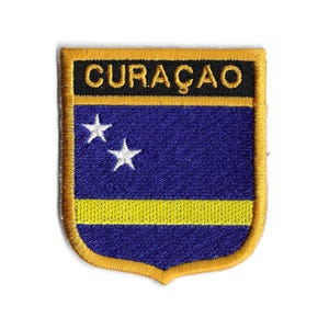 May include: An embroidered patch with a blue background, a yellow stripe, and two white stars. The patch is surrounded by a gold border and has the word "CURAÇAO" in black letters at the top.