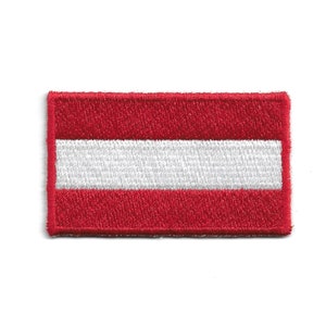 May include: An embroidered patch featuring the Austrian flag, in red and white.