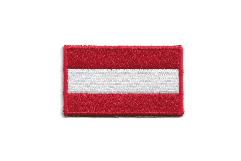 May include: An embroidered patch featuring the Austrian flag, in red and white.