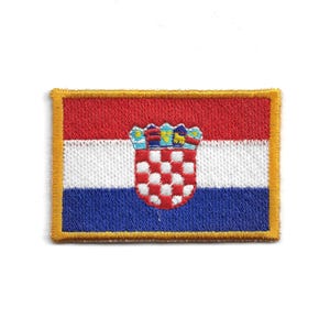 Könnte beinhalten: Gestickter Aufnäher mit der kroatischen Flagge. Der rechteckige Aufnäher hat einen rot-weiß-blauen gestreiften Hintergrund mit einem Wappen in der Mitte. Der Aufnäher ist mit goldfarbenem Faden eingefasst.