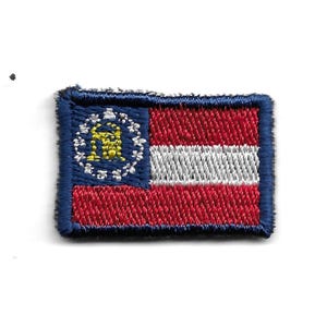 Könnte beinhalten: Gestickter Aufnäher der Staatsflagge von Georgia. Die Flagge ist rot, weiß und blau mit einem goldenen Siegel in der oberen linken Ecke.