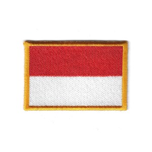 Op de afbeelding: Geborduurde patch met de vlag van Indonesië. De rechthoekige patch heeft een rode bovenste helft en een witte onderste helft, met een gouden rand. De vlag is een symbool van nationale identiteit en trots.