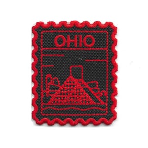 May include: A black and red embroidered patch with a postage stamp design. The patch features the word "OHIO" in red, along with a red outline of a structure. The patch has a red scalloped border.