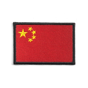 Può includere: Una toppa rettangolare con la bandiera della Cina. La bandiera ha uno sfondo rosso con una grande stella gialla nell'angolo in alto a sinistra e quattro stelle gialle più piccole a destra. La toppa ha un bordo nero.