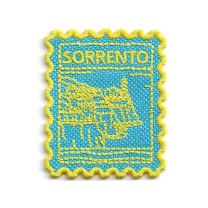 May include: A square, embroidered patch with a light blue background and yellow trim. The patch features the word "SORRENTO" in yellow, along with a yellow illustration of a building. The patch has a postage stamp design.