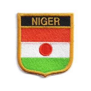 May include: Embroidered patch featuring the flag of Niger. The patch has a shield shape with a gold border. The flag design includes horizontal stripes of orange, white, and green, with a red circle in the center white stripe. The word "NIGER" is embroidered in gold on a black banner.