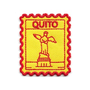 May include: A rectangular embroidered patch with a scalloped red border and a yellow background. The patch features a red stitched outline of a winged statue on a pedestal and the word QUITO in red capital letters at the top center.