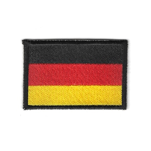 May include: Embroidered patch featuring the German flag. The rectangular patch displays the flag's black, red, and gold horizontal stripes, with a black border. The patch is likely for clothing or accessories.