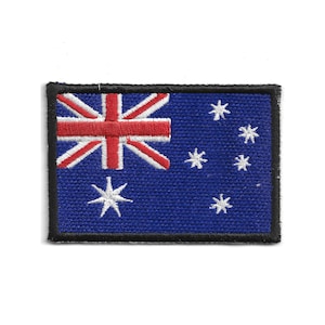 Könnte beinhalten: Gestickter Aufnäher mit der australischen Flagge. Das Design umfasst den Union Jack, einen rot-weißen Commonwealth-Stern und das Sternbild Kreuz des Südens in Weiß. Der Aufnäher hat einen blauen Hintergrund und einen schwarzen Rand.