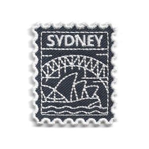 Op de afbeelding: Marineblau geborduurde patch met een witte geschulpte rand, met het Sydney Opera House en de Harbour Bridge. Het woord "SYDNEY" is in wit boven de iconische bezienswaardigheden gestikt, lijkend op een postzegel.