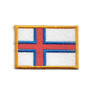 Könnte beinhalten: Gestickter Aufnäher mit der Flagge der Färöer-Inseln. Der rechteckige Aufnäher hat einen weißen Hintergrund mit einem roten nordischen Kreuz, das blau umrandet ist. Der Aufnäher ist mit goldenem Faden eingefasst.