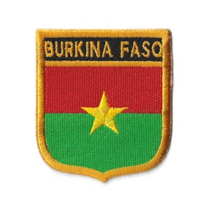 Peut inclure: Un écusson brodé or avec les mots "BURKINA FASO" en lettres noires. L'écusson représente le drapeau du Burkina Faso, avec des couleurs rouge, verte et jaune et une étoile jaune à cinq branches.