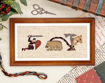 May include: A framed cross-stitch embroidery depicting a knight kneeling with a sword and shield, a bear, and a stylized tree. The embroidery is on a beige linen fabric and is framed in a dark wood frame.