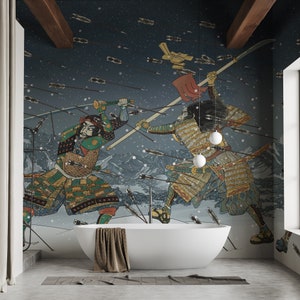 Peut inclure: Une salle de bain avec une baignoire blanche et une fresque murale représentant deux samouraïs en pleine bataille. Le papier peint est bleu foncé avec des flocons de neige blancs et un ciel bleu clair. Les samouraïs portent des armures traditionnelles et tiennent des épées. La scène se déroule sur fond de montagnes et d'arbres.