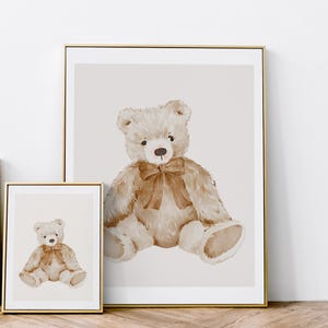 May include: A watercolor painting of a brown teddy bear with a brown bow sitting on a light beige background.
