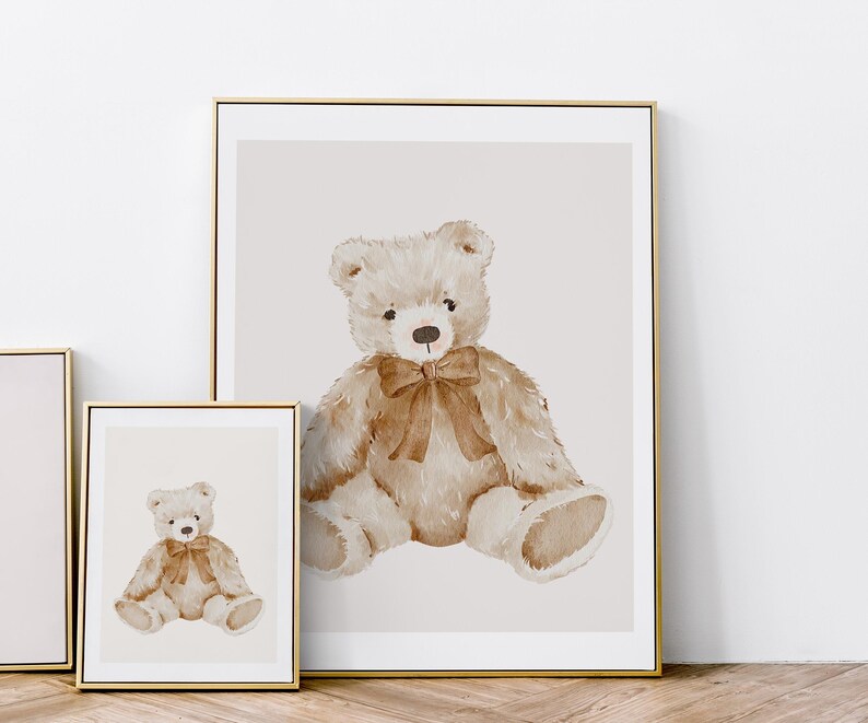 May include: A watercolor painting of a brown teddy bear with a brown bow sitting on a light beige background.