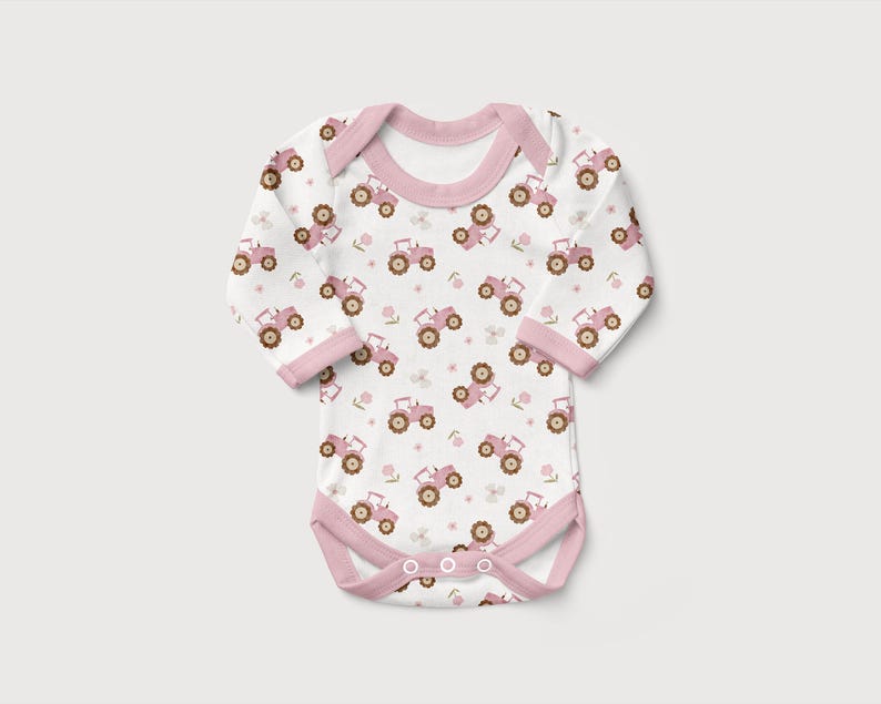 May include: White baby bodysuit with a pink tractor pattern. The long-sleeved onesie features a pink trim around the neckline, sleeves, and leg openings. The tractor design includes pink tractors and small floral accents.