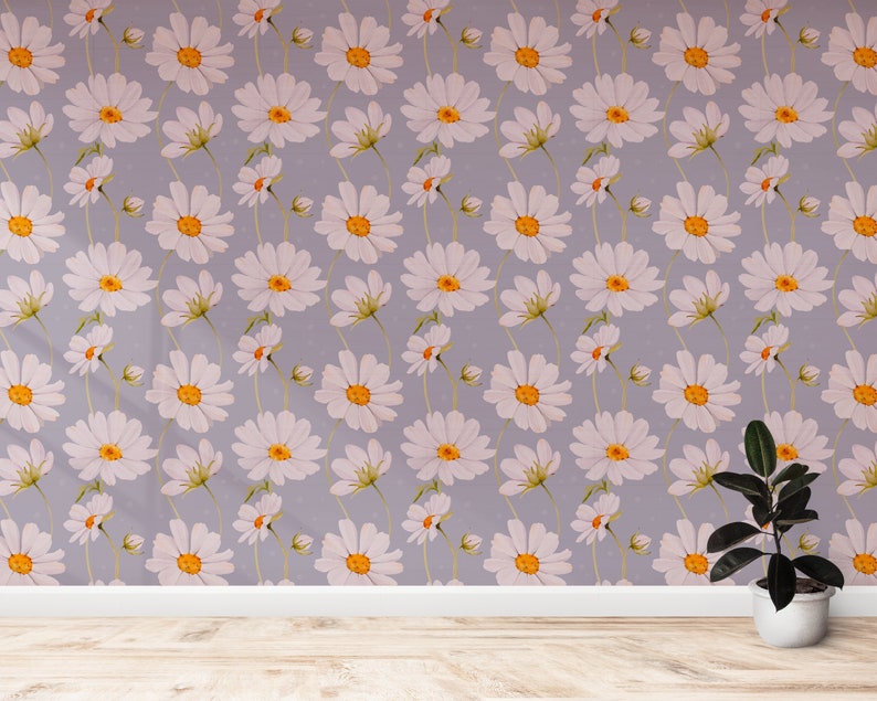 May include: A room with a light purple wall covered in a white daisy pattern. A potted plant with dark green leaves sits on the wooden floor.