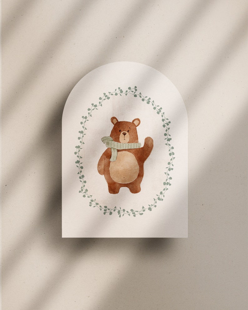 May include: A brown bear wearing a green scarf stands in a wreath of green leaves on a white background.