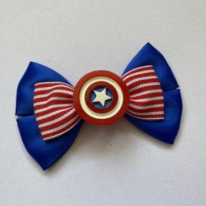 May include: A blue and red bow with a white star in the center. The bow is decorated with a red, white, and blue striped ribbon.