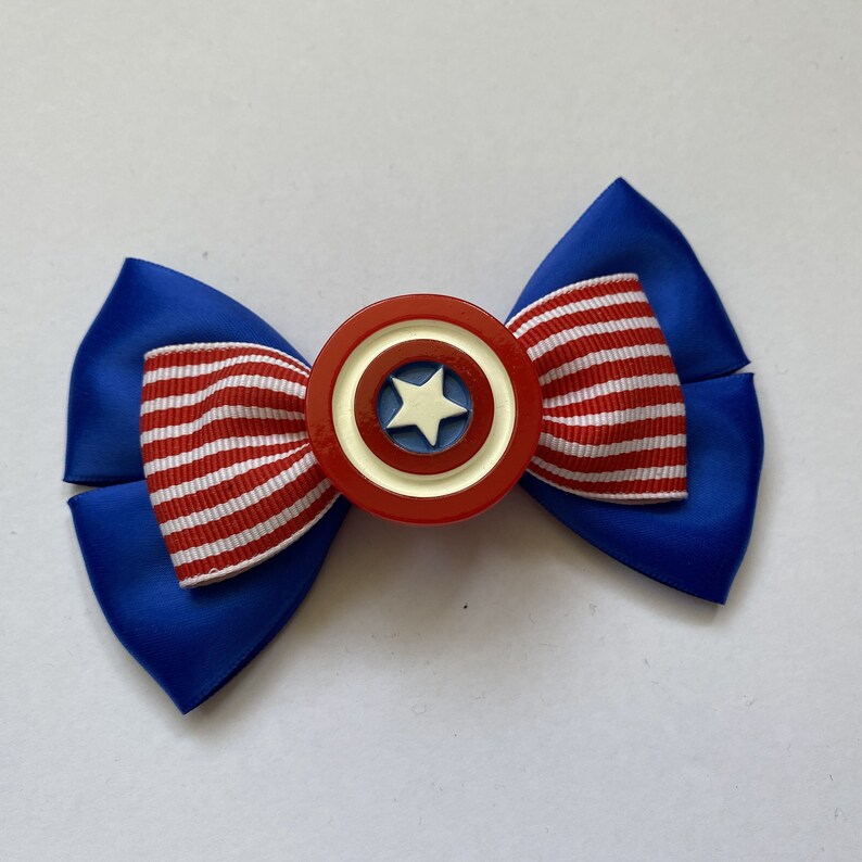May include: A blue and red bow with a white star in the center. The bow is decorated with a red, white, and blue striped ribbon.