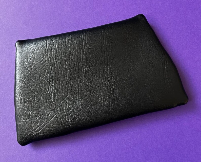 May include: A black leather wallet with a textured surface.