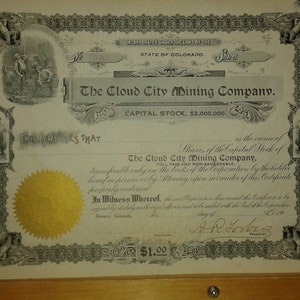 May include: A vintage share certificate for The Cloud City Mining Company, with a capital stock of £2,000,000. The certificate is dated and signed with a gold seal.