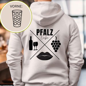 Könnte beinhalten: Ein weißer Kapuzenpullover mit einem schwarzen Aufdruck auf der Rückseite. Das Design zeigt den Text PFALZ Liebe, eine Weinflasche, zwei Weingläser, eine Weintraube und Lippen. Ein kreisförmiger Einschub zeigt ein Glas mit Punktmuster.