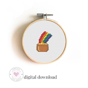 Op de afbeelding: Een kruissteekontwerp van een regenboog boven een pot goud, in een houten borduurring. De regenboog is rood, oranje, geel, groen, blauw en paars. De tekst "digital download" is zichtbaar.