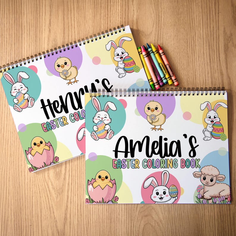 K&ouml;nnte beinhalten: Zwei Spiral-Oster-Malb&uuml;cher mit den Namen "Henry's" und "Amelia's". Die B&uuml;cher zeigen Illustrationen von Hasen, K&uuml;ken und Ostereiern. Ein Satz Buntstifte in verschiedenen Farben befindet sich auf der rechten Seite.