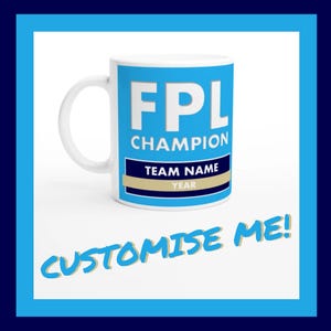 Könnte beinhalten: Eine weiße Keramiktasse mit einem blauen Design, auf dem "FPL Champion" steht, sowie einem goldenen Banner mit der Aufschrift "Team Name" und "Year". Der Text "Customise Me!" ist in Gelb auf blauem Hintergrund geschrieben.