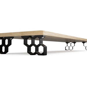 Può includere: Una moderna mensola in legno con un piano in legno chiaro. La mensola è sostenuta da gambe nere geometriche a forma di nido d'ape. Il design è minimalista e contemporaneo, adatto a vari stili di interni.