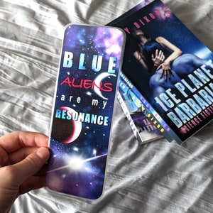 May include: A blue and purple galaxy-themed bookmark with the text "BLUE ALIENS are my RESONANCE".