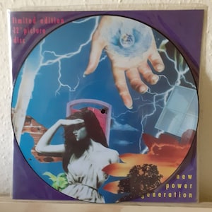 May include: A limited edition 12" picture disc with a collage of images. The images include a hand reaching out from a blue sky with lightning bolts, a woman with her hand over her eyes looking out at a red and orange sky, and a tree in the foreground. The text "new power generation" is printed on the bottom of the disc.