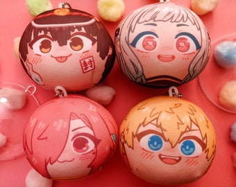 May include: Four plush round character keychains with different colored hair and facial expressions. The characters are all smiling with their eyes closed. The keychains are made of soft, pink fabric and have a white background. The text "寿" is visible on one of the keychains.