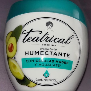 Op de afbeelding: Een witte en blauwgroene pot gezichtscrème met de merknaam "Teatrical" en avocado-illustraties. De pot bevat 400g product en heeft de tekst "crema facial humectante".