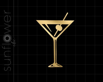 Puede incluir: Una copa de martini dorada con una aceituna verde y un agitador. La copa está sobre un fondo negro.