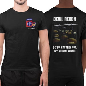 May include: Black t-shirt with a white print on the front and back. The front print is a red, white, and blue patch with the letters "AP" and the text "Airborne 3-73rd CAV". The back print is the text "DEVIL RECON" with a graphic of airplanes and parachutes and the text "3-73rd CAVALRY RGT. 82nd AIRBORNE VETERAN".