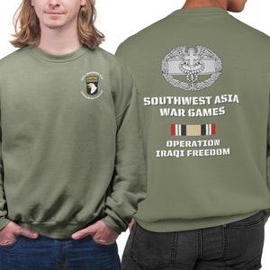 May include: Green sweatshirt with a military patch on the left chest and text on the back that reads "Southwest Asia War Games Operation Iraqi Freedom".