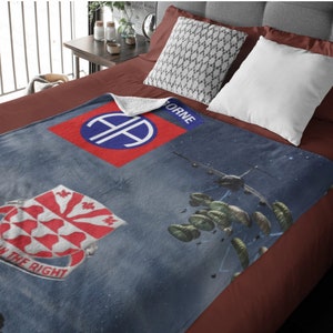 May include: A blue fleece blanket with a red and blue military insignia, a red and white crest, and a depiction of paratroopers in the sky. The text "101st Airborne" and "In the Right" are visible on the blanket.