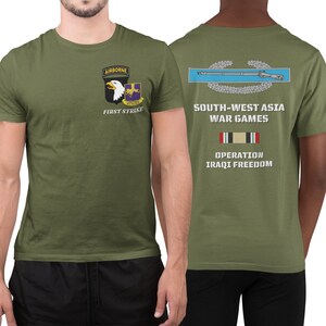 May include: A green t-shirt with a military patch on the front that says "Airborne First Strike" and a military patch on the back that says "South-West Asia War Games Operation Iraqi Freedom".