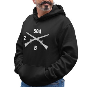 May include: Black hooded sweatshirt with a white graphic of two crossed rifles and the text "2 504 B".