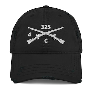 May include: A black distressed baseball cap with a white embroidered design of crossed rifles and the text "325 4 C".