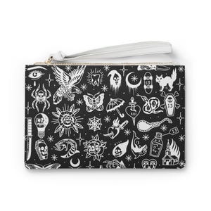 May include: Black clutch bag with a white wrist strap and gold zip. The bag displays a repeating pattern of white tattoo-style illustrations, including an eagle, spider, butterfly, skull, and more.