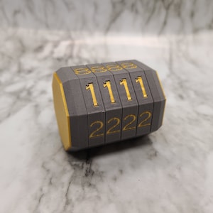 Op de afbeelding: Een grijs en gouden combinatie slot met de nummers 1111 en 2222.