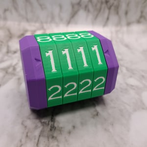 May include: A purple and green combination lock with a series of rotating dials. The dials display the numbers 888, 1111, and 2222.