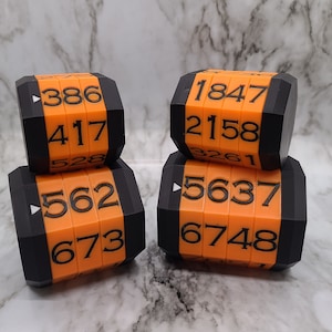 May include: Four black and orange dice with numbers 386, 417, 528, 562, 673, 1847, 2158, 3261, 5637, and 6748.
