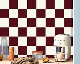 May include: A white and burgundy checkered tile backsplash in a kitchen with a white countertop and a vintage-style Smeg coffee maker.